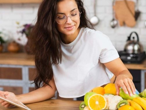 medium-shot-woman-with-fruits-tablet_23-2148302150